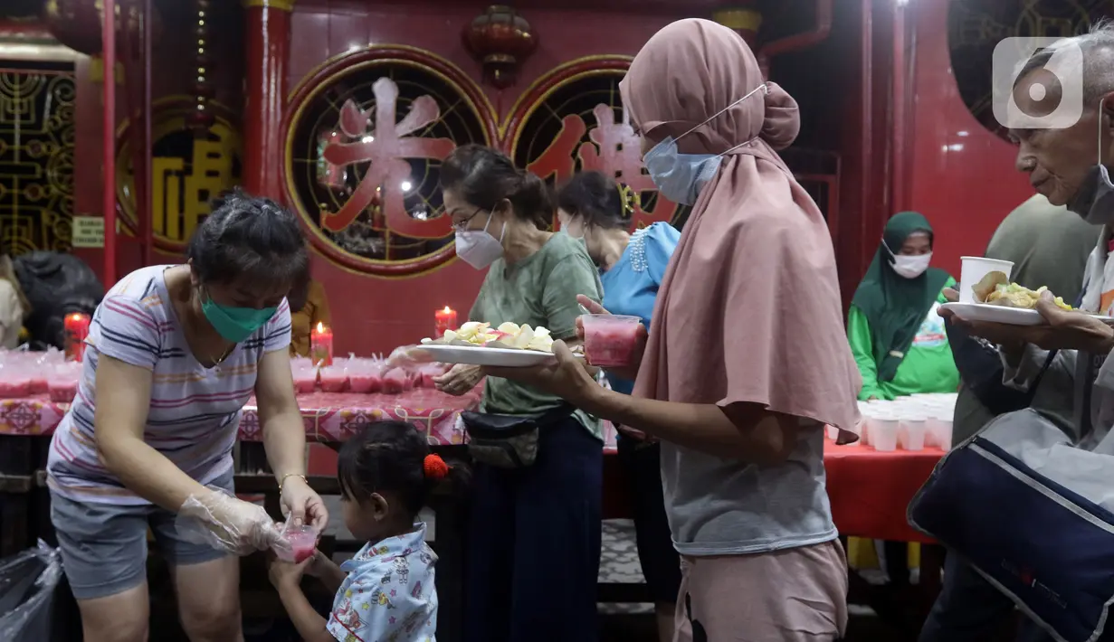 Warga menerima makanan berbuka puasa di Vihara Dharma Bhakti, Petak Sembilan, Jakarta, Kamis (7/4/2022). Yayasan Vihara Dharma Bhakti menyediakan sekitar 200 porsi menu berbuka puasa bagi warga sekitar untuk lebih mempererat persaudaraan umat beragama. (Liputan6.com/Helmi Fithriansyah)