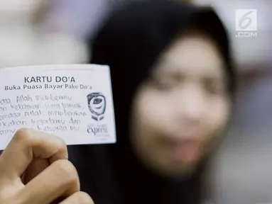 Pengunjung menunjukkan kartu doa di Kedai Soto Kauman Express Sawangan, Depok, Jawa Barat, Senin (13/5). Selama Ramadan, kedai soto ini menyediakan satu paket menu buka puasa terdiri dari soto, siomay, kurma, dan minuman cukup dibayar dengan doa pada secarik kertas. (Liputan6.com/Immanuel Antonius)