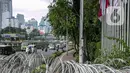 Kawat berduri membentang menghalangi jalur pejalan kaki atau pedestrian di Jalan Gatot Subroto, Jakarta, Selasa (2/2/2021). Keberadaan kawat berduri tersebut mengganggu akses pejalan kaki serta menutup jalur pemandu khusus penyandang disabilitas (guiding block). (Liputan6.com/Faizal Fanani)