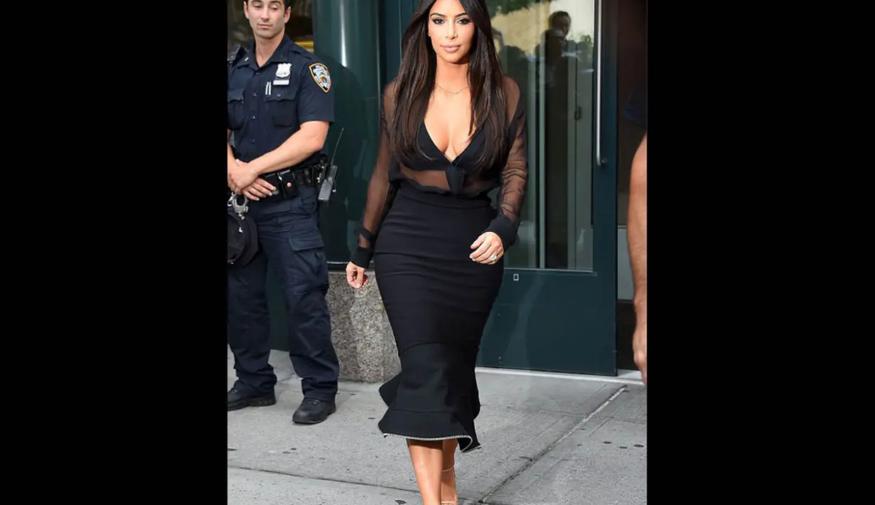 Seorang petugas tak melepaskan pandangannya saat melihat Kim Kardashian melangkah keluar dari apartemennya di New York City, Minggu (10/8/14). (Dailymail)