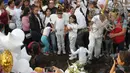 Anak-anak bernyanyi di sebelah kuburan Fatima, korban pembunuhan berusia 7 tahun di Mexico City  (18/2/2020). Jasad Fatima ditemukan terbungkus tas dan ditinggalkan di daerah pedesaan pada hari Sabtu. (AP Photo/Marco Ugarte)