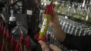 Belal Abu Saraya berpose dengan wadah parfum yang melambangkan roket yang digunakan untuk melawan Israel di sebuah toko parfum yang digunakan untuk melawan Israel dalam konflik masa lalu di tokonya di Kota Gaza pada Kamis, 5 Oktober 2023. (AP Photo/Fatima Shbair)