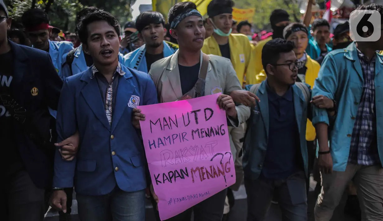 Massa mahasiswa dari BEM Seluruh Indonesia (SI) membawa poster dalam unjuk rasa di kawasan Patung Kuda, Jakarta, Senin (21/10/2019). Massa yang akan berunjuk rasa di depan Istana Merdeka tertahan di Patung Kuda karena terhalang kawat berduri yang dibentangkan. (Liputan6.com/Faizal Fanani)