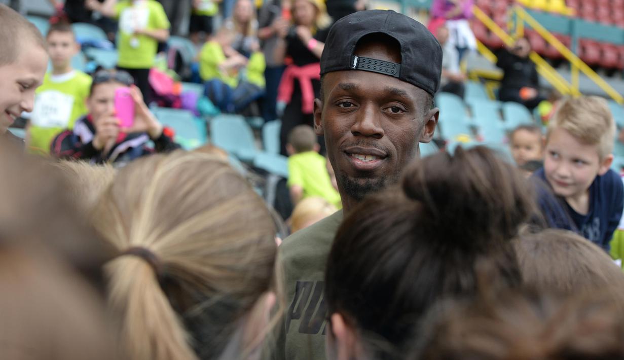 Usain Bolt dikerubutin para pelari cilik saat berkunjung ke track lari di Prague, Bolt datang ke Republik Ceska guna mengikuti pertemuan Golden Spike di Ostrava,Republik Ceska.    (18/5/2016). (AFP/Michal Cizek)