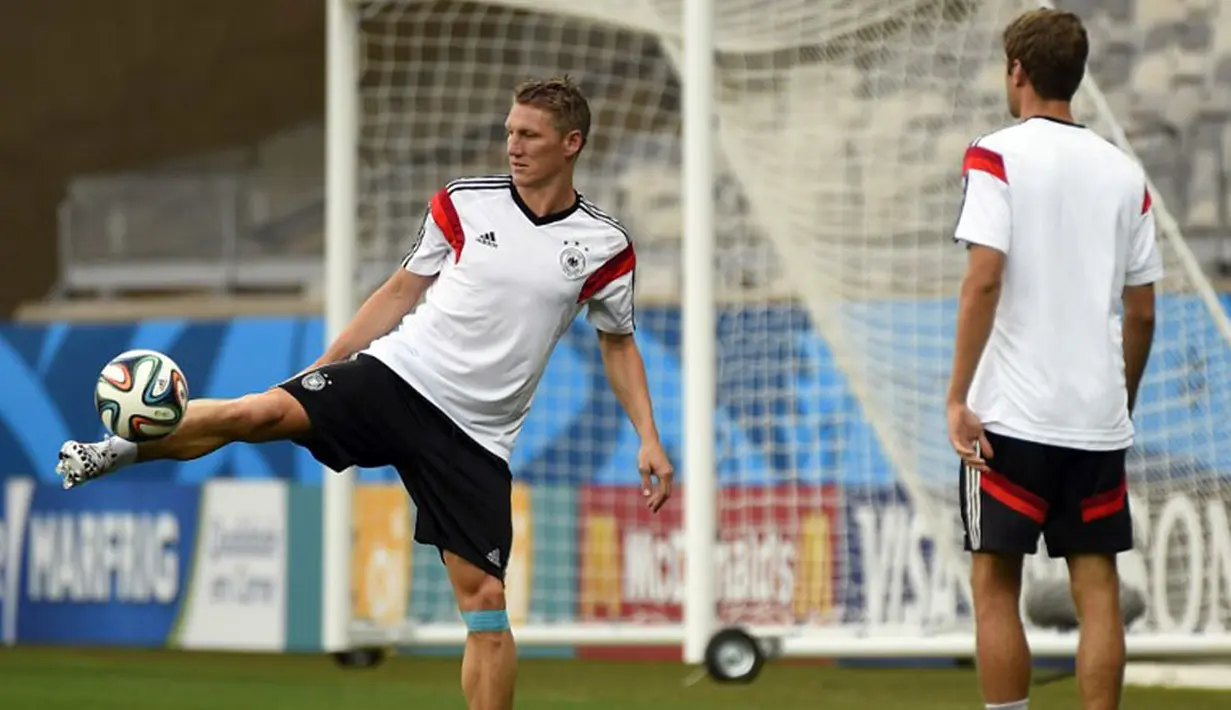 Bastian Schweinsteiger (kiri) memainkan bola saat berlatih di Stadion Mineirao, Belo Horizonte (7/7/2014). (AFP PHOTO/ODD Andersen)