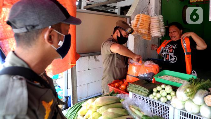 Pelanggar PSBB mengenakan rompi khusus saat razia masker di Pasar Reni, Pamulang, Tangerang Selatan, Banten, Selasa (1/9/2020). Razia terhadap pedagang dan pengunjung pasar ini juga dilakukan rapid test guna mencegah penularan COVID-19. (merdeka.com/Arie Basuki)