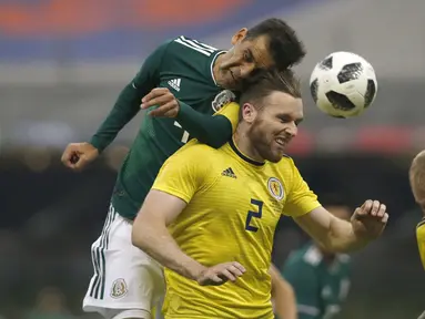Duel pemain Meksiko, Rafael Marquez (kiri) dengan pemain Skotlandia, Stephen O'Donnell (tengah) pada laga uji coba di Azteca Stadium, Meksiko City, (2/6/2018). Meksiko menang 1-0. (AP/Rebecca Blackwell)