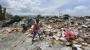 Seorang pria mencari barang yang tersisa di bangunan rumahnya yang hancur akibat gempa dan tsunami di Petobo, Palu, Kamis (4/10). Wilayah Kelurahan Petobo di Palu menjadi salah satu daerah yang terkena dampak parah karena 'ditelan bumi'. (AFP/ ADEK BERRY)
