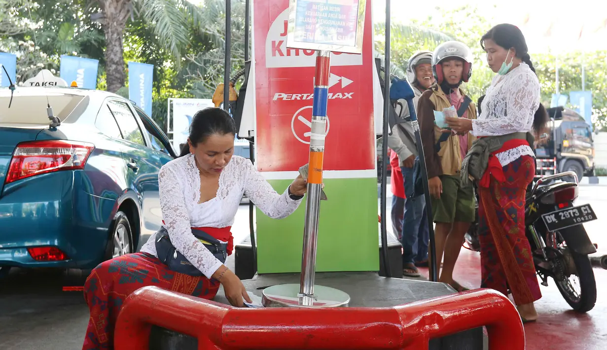 Aktivitas petugas dengan pakaian adat di sebuah SPBU, Bali, Rabu (10/10). Petugas SPBU mengenakan pakaian adat Bali untuk menyambut pertemuan tahunan IMF dan Bank Dunia. (Liputan6.com/Angga Yuniar)