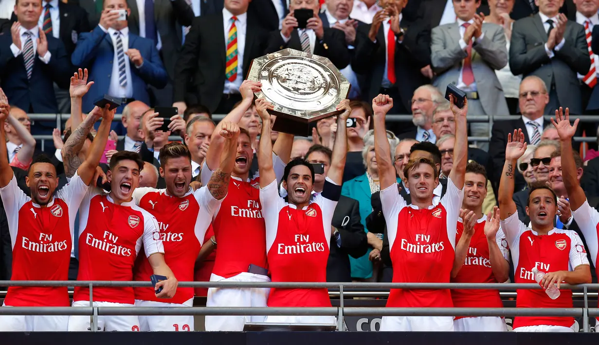 Gelandang Arsenal, Mikel Arteta bersama pemain lainnya mengangkat trofi usai memenangkan gelar FA Community Shield di Wembley Stadium, Minggu (2/8/2015). Arsenal menang atas Chelsea dengan skor 1-0. (Reuters/Andrew Couldridge)