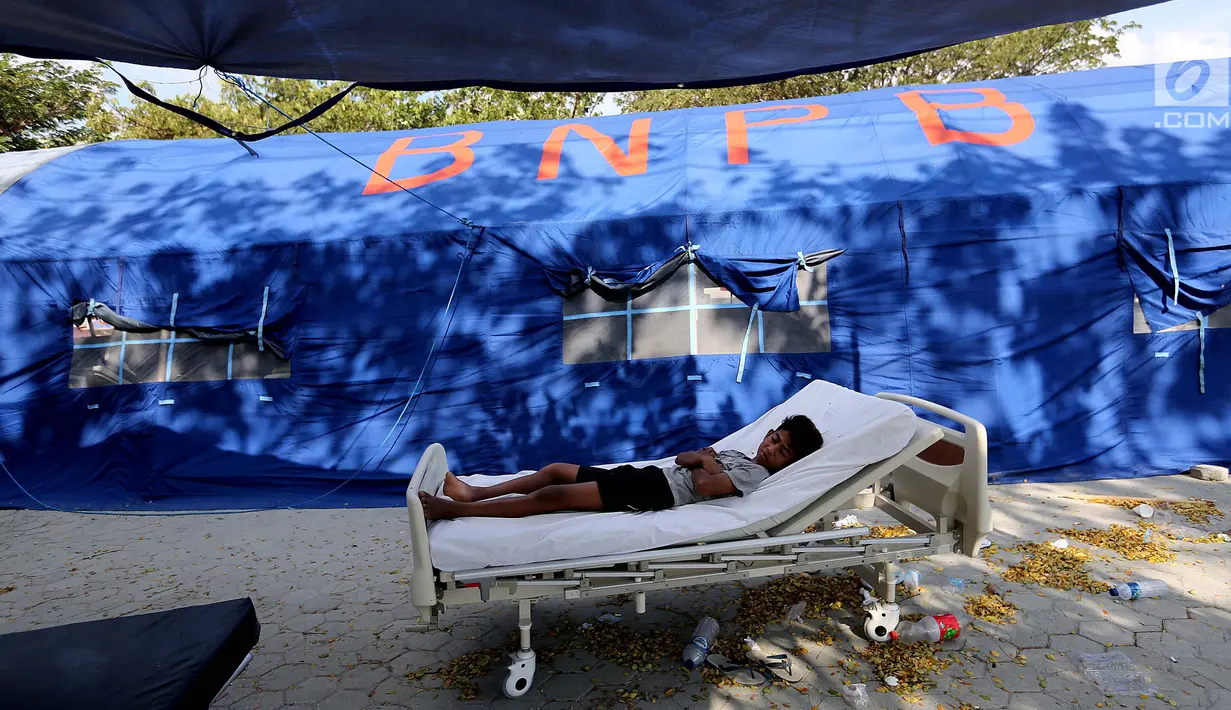 Pasien tertidur di halaman Rumah Sakit Undata, Palu, Sulawesi Tengah, Kamis (4/10). Puluhan pasien korban gempa bumi dan tsunami Palu dirawat dengan kondisi seadanya. (Liputan6.com/Fery Pradolo)