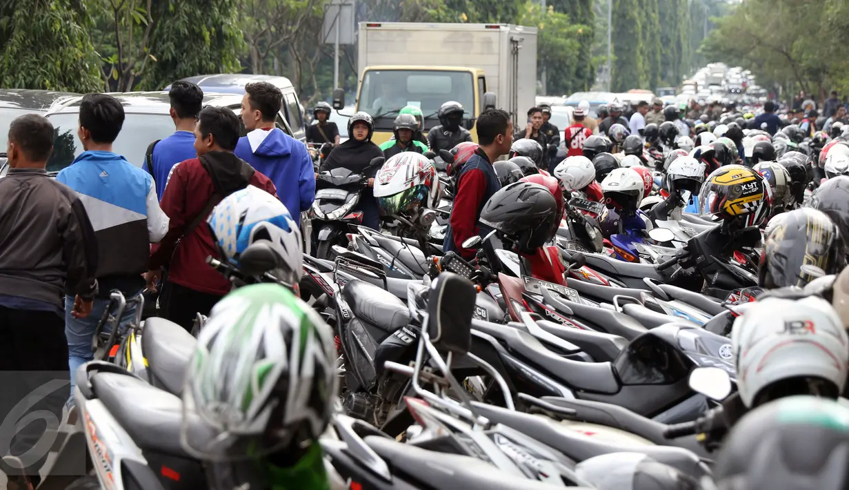 Ratusan motor terparkir di jalur cepat Jalan Tegar Beriman Kab Bogor, Selasa (13/12). Ribuan calon suporter Timnas Indonesia antre membeli tiket laga final pertama di halaman Kodim 0621 Surya Kancana. (Liputan6.com/Helmi Fithriansyah)