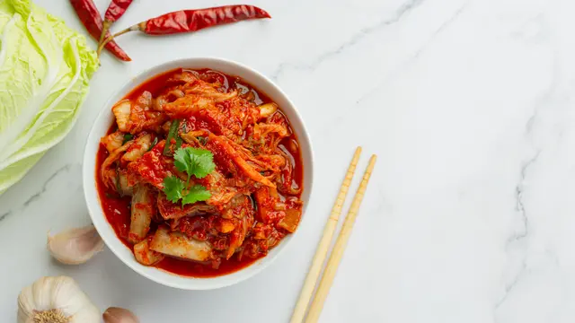 Semangkuk kimchi bersama sepasang sumpit dan satu siung bawang putih (Foto Dok: Freepik/freepik)