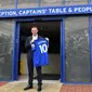 Penyerang baru Everton Wayne Rooney, memegang kostum tim barunya setelah konferensi pers di Goodison Park di Liverpool (10/8). Rooney mengawali karier bersama Everton pada 1996 dan masuk skuad utama pada 2002. (AFP Photo/Paul Ellis)