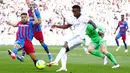 Pemain Barcelona Jordi Alba (kiri) mencoba untuk memblokir tendangan Real Madrid Vinicius Junior pada pertandingan La Liga Spanyol di Stadion Camp Nou, Barcelona, Spanyol, Minggu (24/10/2021). Real Madrid menang 2-1. (AP Photo/Joan Monfort)