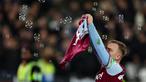 Pemain West Ham United, Jarrod Bowen melakukan selebrasi dengan menunjukkan jersey milik Michail Antonio pada laga lanjutan Liga Inggris 2024/2025 melawan Wolves di London Stadium, London, Inggris, Selasa (10/12/2024) WIB. (AFP/Adrian Dennis)