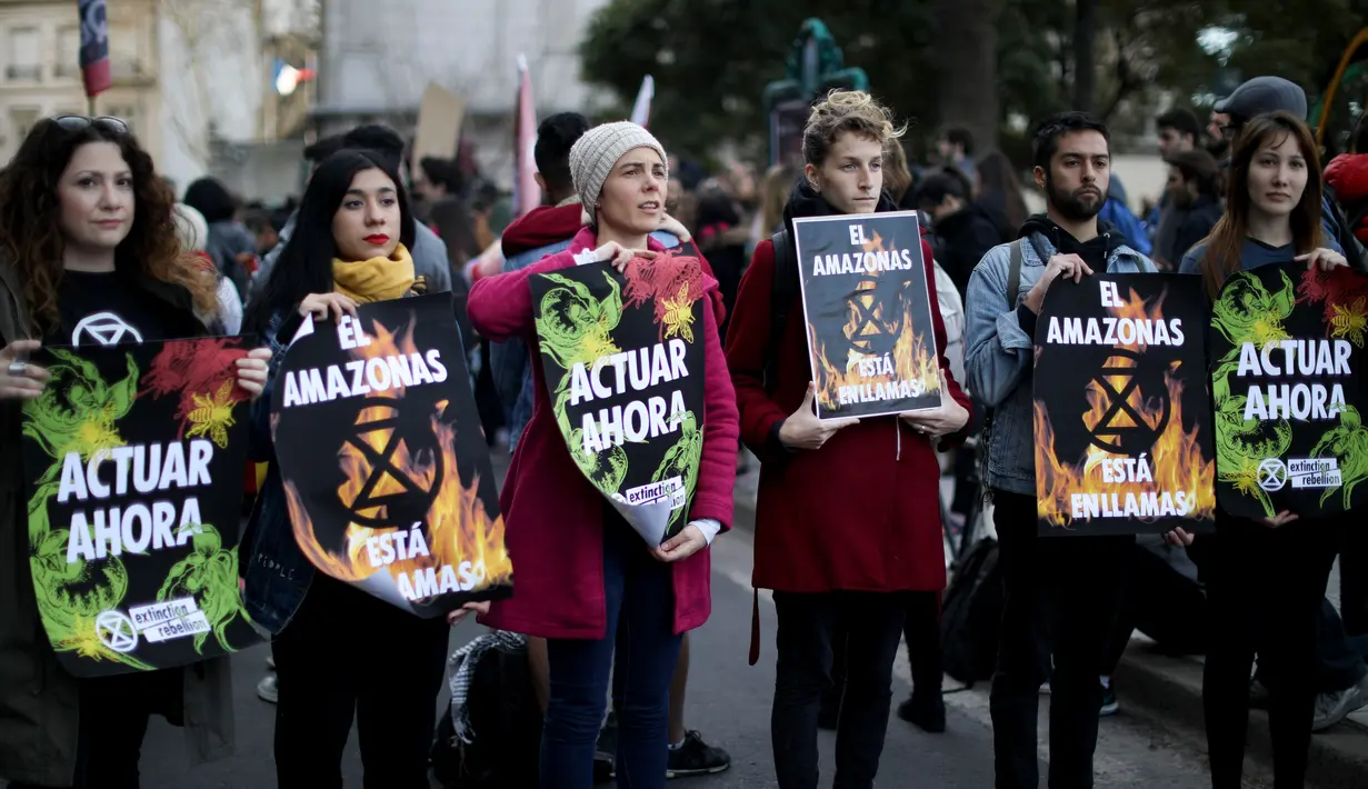 Sejumlah wanita memegang spanduk bertuliskan 'Amazon sedang terbakar, bertindak sekarang' selama protes meminta Presiden Brasil Jair Bolsonaro bertindak atas terbakarnya hutan Amazon di luar Kedutaan Besar Brasil di Buenos Aires, Argentina, Jumat (23/8/2019. (AP Photo/Natacha Pisarenko)