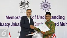 Dubes Inggris untuk Indonesia Moazzam Malik (kiri) bersama Ketua Umum PP Muhammadiyah Haedar Nasir melakukan penandatanganan nota kesepahaman di Jakarta, Senin (16/5). (Liputan6.com/Immanuel Antonius)