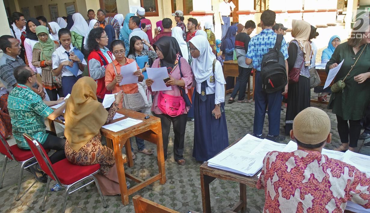 Suasana saat para siswa dengan orangtua murid akan mengikuti seleksi Penerimaan Peserta Didik Baru (PPDB) di SMAN 1 Depok, Kota Depok, Jawa Barat, Selasa (18/6/2019). Sistem PPDB Jawa Barat berlangsung pada tanggal 17-22 Juni 2019. (Liputan6.com/Herman Zakharia)