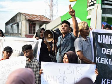 Para pengunjuk rasa memegang poster saat unjuk rasa di Sabang, Provinsi Aceh, Indonesia, Senin (18/12/2023). (AP Photo/Reza Saifullah)