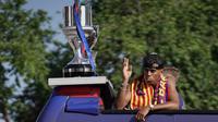 Pemain depan Barcelona asal Spanyol bernomor punggung 19, Lamine Yamal, melambaikan tangan kepada para pendukung dari atas bus terbuka saat para pemain Barcelona merayakan kemenangan mereka atas gelar La Liga ke-28 di Barcelona, ​​pada 16 Mei 2025. (Manaure Quintero/AFP)