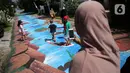 Warga berfoto di atas jalan yang telah dilukis mural di Jalan Keuangan, Cilandak, Jakarta, Rabu (26/8/2020). Museum Basoeki Abdullah bekerjasama dengan Perupa Jakarta Raya membuat mural dengan memanfaatkan ruang publik di sepanjang jalan menuju museum Basoeki Abdullah. (Liputan6.com/Faizal Fanani)