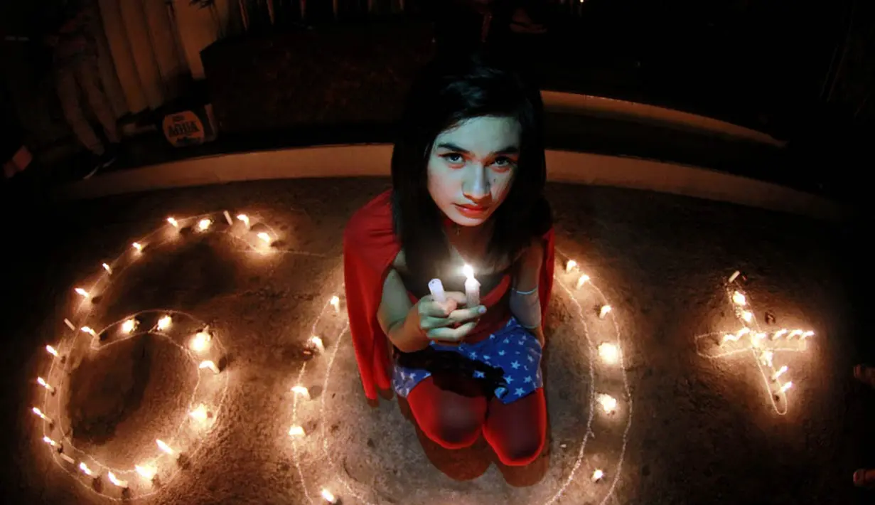 Seorang gadis yang berkostum ala Wonder Woman berpose dalam aksi Global Earth Hour di Gorontalo (ANTARA FOTO/Adiwinata Solihin)
