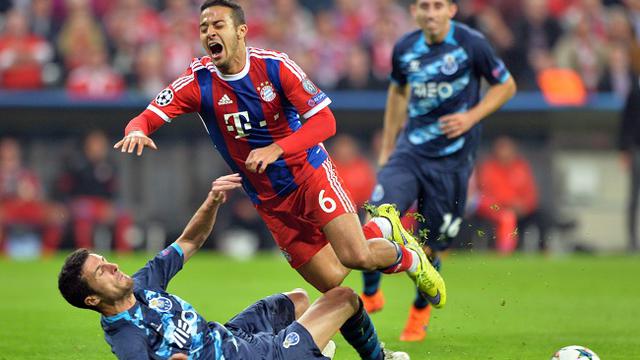 Thiago Alcantara (kanan) dilanggar keras oleh pemain Porto Ivan Marcano di Leg kedua perempat final Liga Champions (21/4/2015). (EPA // MARC MUELLER)