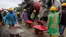 Sementara PTPP berperan dalam pelaksanaan pembangunan hunian secara cepat, terukur, dan sesuai standar keselamatan konstruksi. Tampak dalam foto, para pekerja mengangkut beton dengan gerobak dorong selama pembangunan unit perumahan sementara yang dibangun oleh Danantara, Badan Pengelola Investasi (BPI) strategis Indonesia, di Aceh Tamiang, provinsi Aceh, pada Kamis 8 Januari 2026. (ADITYA AJI/AFP)