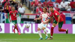 Pemain Kroasia Luka Modric (tengah) berebut bola dengan pemain Maroko Selim Amallah pada pertandingan sepak bola Grup F Piala Dunia 2022 di Stadion Al Bayt, Al Khor, Qatar, Rabu (23/11/2022). Pertandingan berakhir imbang dengan skor 0-0. (AP Photo/Aijaz Rahi)