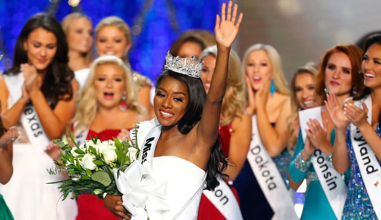 Miss New York Nia Franklin melambaikan tangan ke penonton usai dinobatkan sebagai Miss America 2019 di Atlantic City, New Jersey (9/10). Franklin 24 tahun telah menyelesaikan sarjana komposisi musik di East Carolina University. (AP Photo/Noah K. Murray)