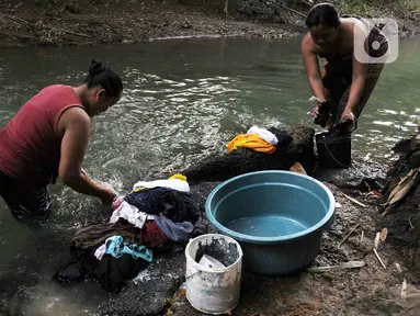 Warga mencuci pakaian di aliran Kali Cihoe, Cibarusah, Kabupaten Bekasi, Jawa Barat, Rabu (19/7/2023). Warga memanfaatkan Kali Cihoe untuk mandi dan mencuci pakaian saat musim kemarau karena sumur mereka kekeringan. (merdeka.com/Imam Buhori)