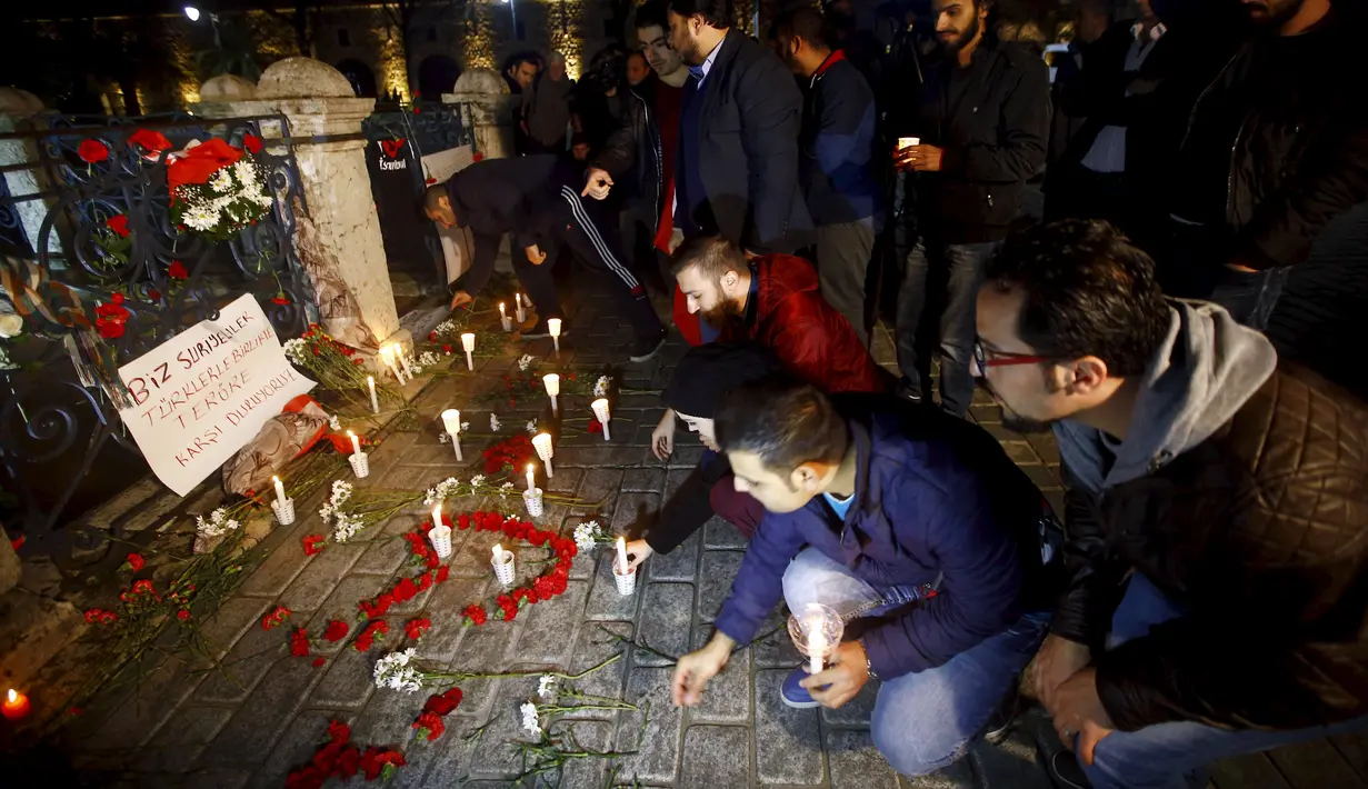 Seorang pria Suriah yang tinggal di Turki meletakkan lilin di lokasi bom bunuh diri di Sultanahmet Square, Istanbul, Rabu (13/1). Bunga dan lilin tersebut wujud belasungkawa untuk korban ledakan di Turki. (REUTERS/Osman Orsal)