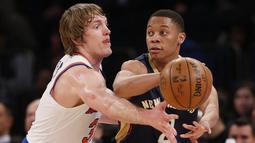 Pemain Pelicans, Tim Frazier (kanan) mengumpan bola melewati hadangan pemain New York Knicks, Ron Baker (kiri) pada laga NBA basketball game di Madison Square Garden, New York (9/1/2017). Pelicans menang 110-96.  (AP/Kathy Willens)