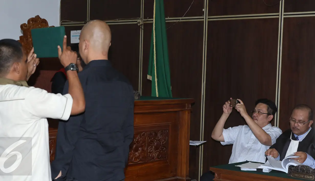 Farhat Abbas mengabadikan gambar saat musisi Ahmad Dhani diambil sumpahnya sebelum memberi kesaksian pada sidang lanjutan kasus pencemaran nama baik yang dilayangkan Ahmad Dhani di Pengadilan Negeri Jaksel, Kamis (19/11). (Liputan6.com/Herman Zakharia)