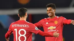 Striker Manchester United, Marcus Rahford merayakan gol bersama Bruno Fernandes dalam lanjutan Liga Champions 2020/2021 di grup H saat menghadapi RB Leipzig di Stadion Old Trafford, Kamis (29/10/2020) dini hari WIB. Manchester United menang 5-0 atas RB Leipzig. (AFP/Anthony Devlin).