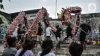 Anak-anak menyaksikan anggota Naga Merah Putih saat latihan Liong di kawasan Babakan Pasar, Bogor, Jawa Barat, Senin (17/1/2022). Jelang perayaan Tahun Baru Imlek, klub kesenian Tionghoa tersebut rutin melakukan latihan memainkan Liong dan Barongsai. (merdeka.com/Iqbal S. Nugroho)