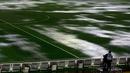 Seorang kamerawan berdiri di pinggir lapangan Stadion Monumental, Buenos Aires, Argentina, yang banjir karena guyuran hujan deras sebelum laga Kualifikasi Piala Dunia 2018 antara Argentina melawan Brasil. Jumat (13/11/2015) WIB. (Reuters/Marcos Brindicci)