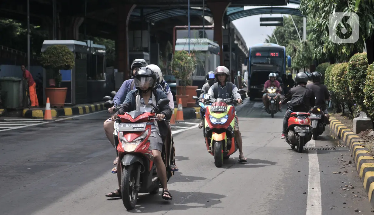 Pengendara motor melintasi Gerbang Tol Pulomas saat dialihkan akibat banjir di kawasan Cempaka Putih, Jakarta, Minggu (23/2/2020). Banjir yang melanda kawasan tersebut melumpuhkan akses di Jalan Ahmad Yani sehingga Gerbang Tol Pulomas dibuka untuk pengendara motor. (merdeka.com/Iqbal S. Nugroho)