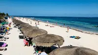 Wisatawan menikmati pantai di Puerto Morelos, negara bagian Quintana Roo, Meksiko (14/2). Kota ini terletak di timur laut negara bagian, sekitar 36 km selatan kota resor Cancún, dan sekitar 30 km utara kota Playa del Carmen. (AFP Photo/Daniel Slim)