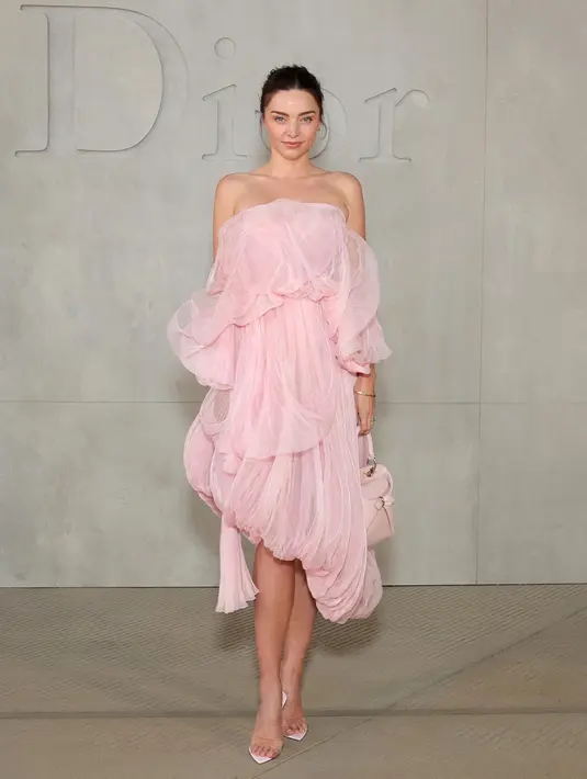 Miranda Kerr tampil elegan dengan dress strapless ruffle warna soft pink dipadukan heels transparannya. [Dok. DIOR]