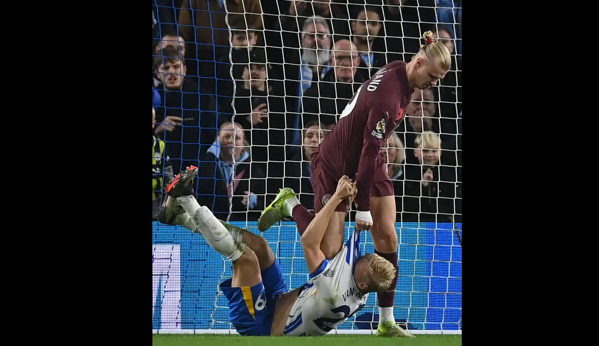 Pemain Manchester City, Erling Haaland (atas) saling menarik jersey saat bersitegang dengan pemain Brighton, Paul Van Hecke pada laga lanjutan Liga Inggris 2024/2025 yang berlangsung di American Express Community Stadium, Brighton, Inggris, Minggu (10/11/2024) WIB. (AFP/Glyn Kirk)