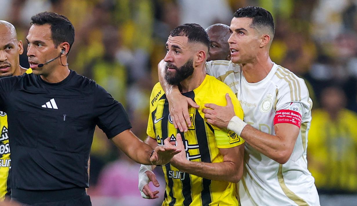 Pemain Al Nassr, Cristiano Ronaldo (kanan) mencoba meredam emosi dari pemain Ittihad FC, Karim Benzema pada laga lanjutan Liga Arab Saudi di King Abdullah Sports City, Jeddah, Arab Saudi, Sabtu (07/12/2024) dini hari WIB. (AFP)
