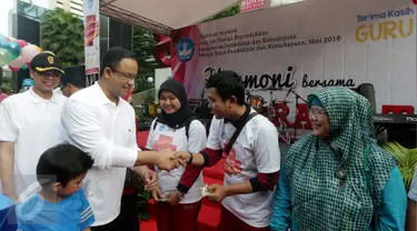 Menteri Pendidikan & Kebudayaan, Anies Baswedan secara simbolis memberikan kartu ATM Bank bjb di Senayan, Jakarta, Minggu (24/04). Bank bjb memberikan apresiasi berupa kartu bjb cinta guru. (Liputan6.com/Fery Pradolo)  