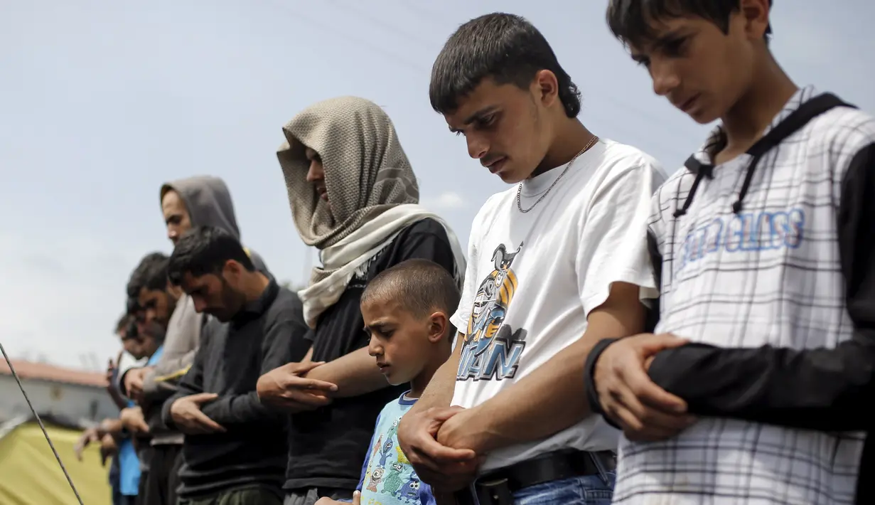 Seorang anak tampak khusyuk melakukan salat Jumat di sebuah kamp darurat perbatasan Yunani-Makedonia,desa Idomeni, Yunani (8/4). Meski tengah mencari perlindungan, mereka tak melalaikan kewajibannya sebagai seorang muslim. (REUTERS/Marko Djurica)