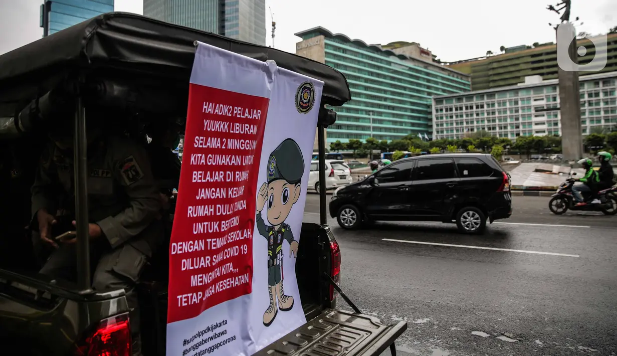 Petugas Satpol PP melakukan sosialisasi kepada masyarakat guna mencegah penularan Covid-19 di Bundaran HI, Jakarta, Kamis (19/3/2020). Sosialisasi yang mengajak masyarakat untuk menerapkan PHBS untuk mengantisipasi penyebaran Covid-19. (Liputan6.com/Faizal Fanani)