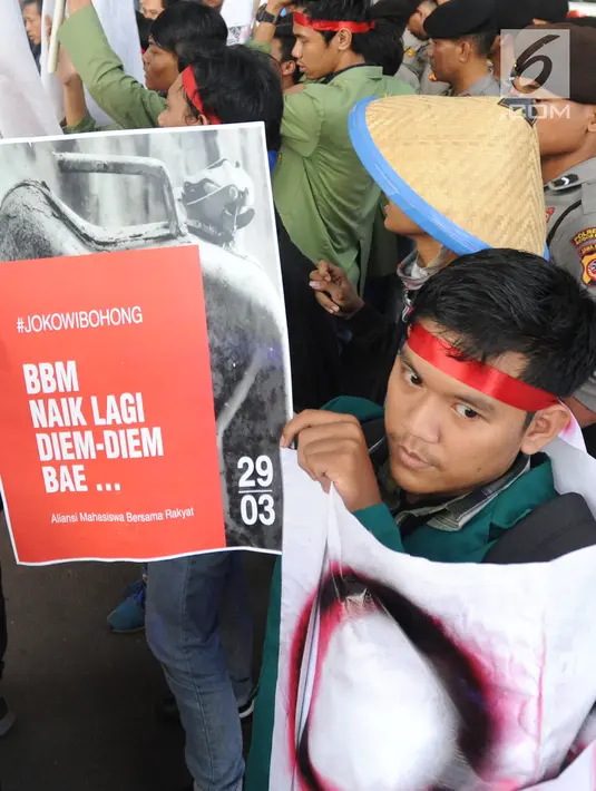 Seorang mahasiswa yang tergabung dalam Kesatuan Aksi Mahasiswa Muslim Indonesia (KAMMI) Bogor menunjukkan poster saat melakukan aksi menolak harga kenaikan BBM di Jalan Ir. H.Djuanda, Bogor (29/03). (Merdeka.com/Arie Basuki)