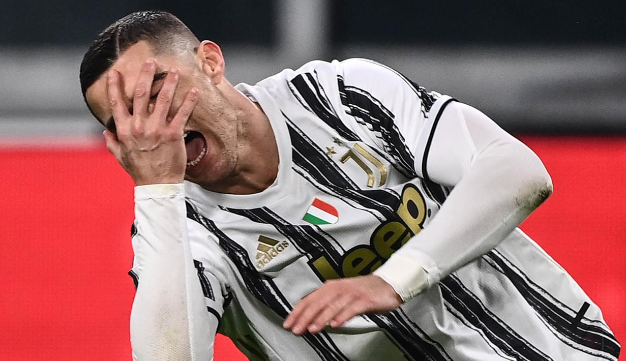 Striker Juventus, Cristiano Ronaldo, menutup wajahnya usai gagal mencetak gol ke gawang Fiorentina pada laga Liga Italia di Turin, Rabu (23/12/2020). Fiorentina menang dengan skor 0-3. (Photo by Marco BERTORELLO / AFP)
