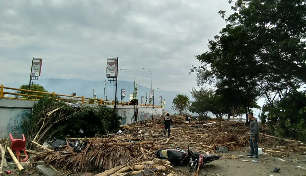 Warga memeriksa kerusakan akibat gempa dan tsunami di Palu, Sulawesi Tengah , Sabtu (29/9). Gelombang tsunami setinggi 1,5 meter yang menerjang Palu terjadi setelah gempa bumi mengguncang Palu dan Donggala. (AFP /OLA GONDRONK)