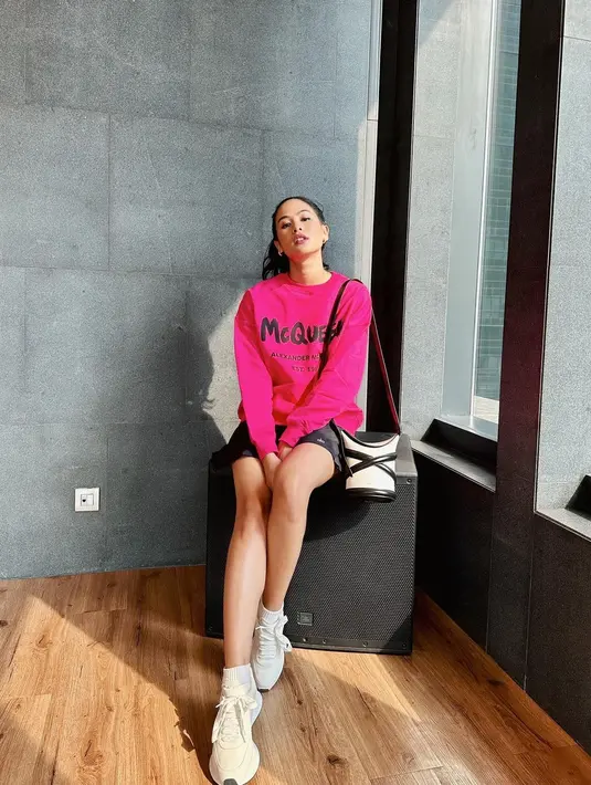 Siapa takut tampil bold dengan warna pink seperti terlihat pada Maudy Ayunda di foto ini? Tampilan simpel dan chic ala Maudy Ayunda mengenakan oversized sweater berwarna pink dan celana pendek hitam, dipadunya dengan sneakers putih dan mini sling bag yang juga bernuansa putih-hitam. Foto: Instagram.